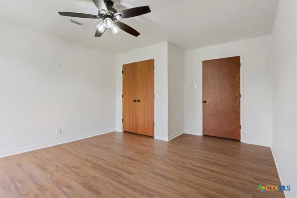 a view of an empty room with wooden floor