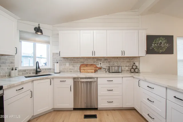 a living room with furniture kitchen view and a chandelier