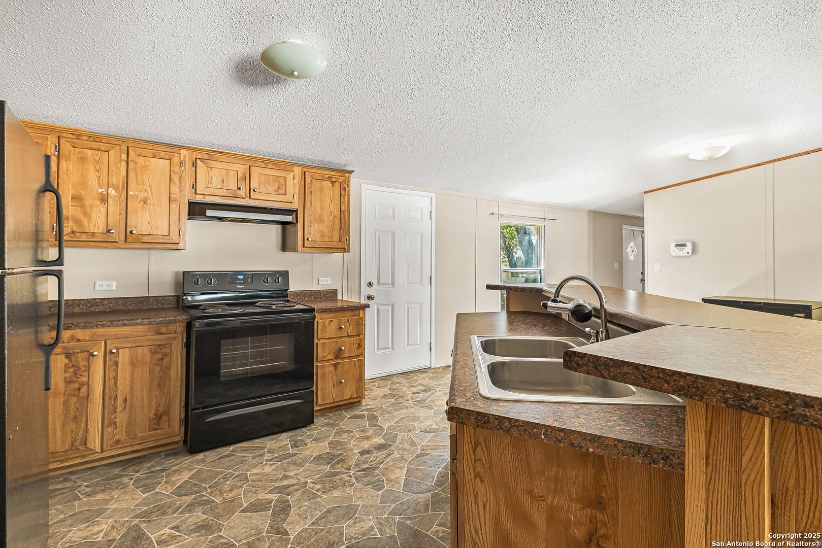 823 County Road 6850 Lytle, TX 78052 - Photo 12 of 33 a kitchen with a stove a sink and a refrigerator