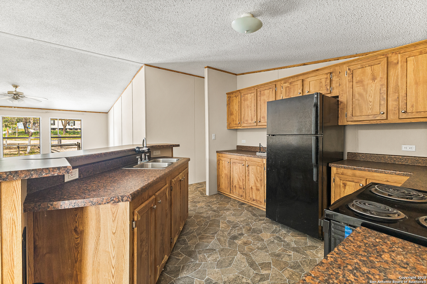 823 County Road 6850 Lytle, TX 78052 - Photo 13 of 33 a kitchen with kitchen island granite countertop a sink stove and refrigerator