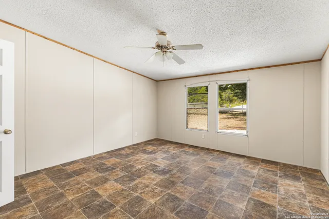 an empty room with windows and fan