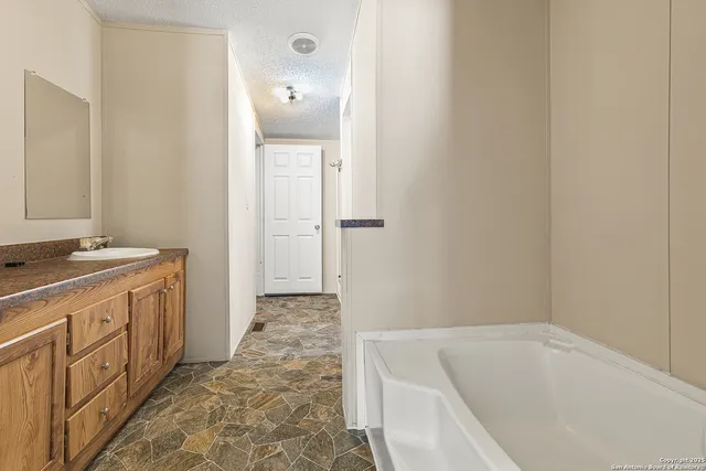 a bathroom with a tub sink and mirror