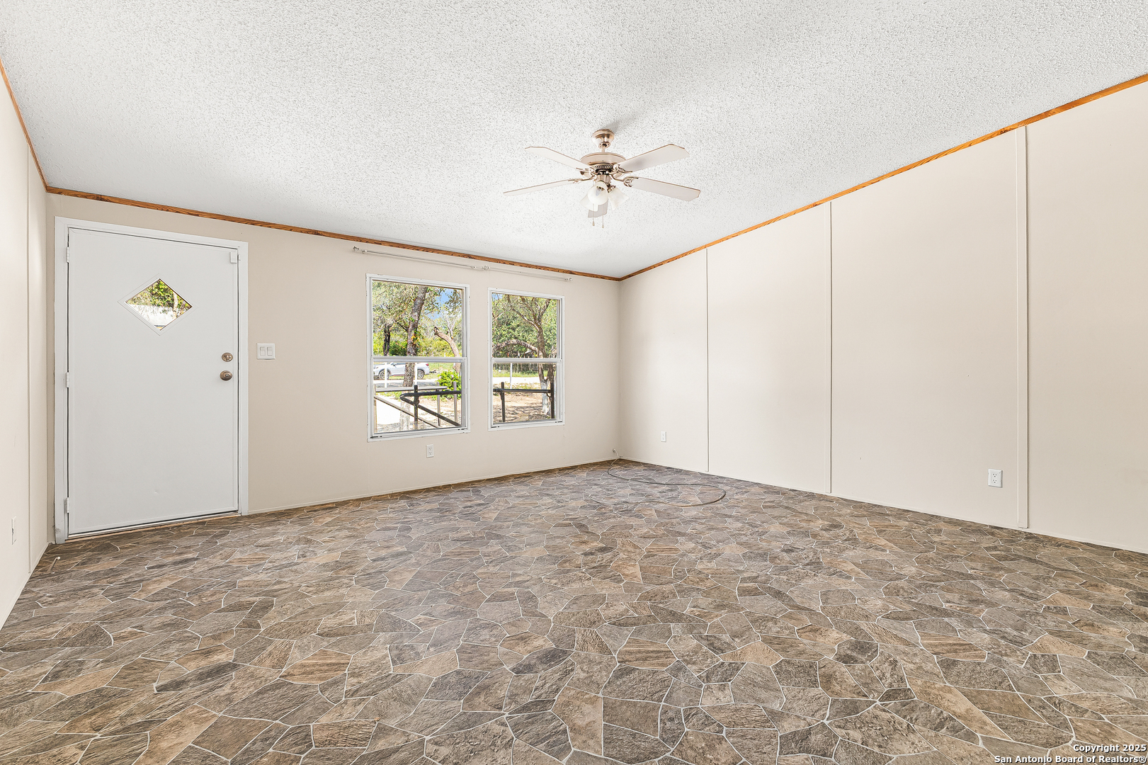 823 County Road 6850 Lytle, TX 78052 - Photo 8 of 33 an empty room with windows and ceiling fan