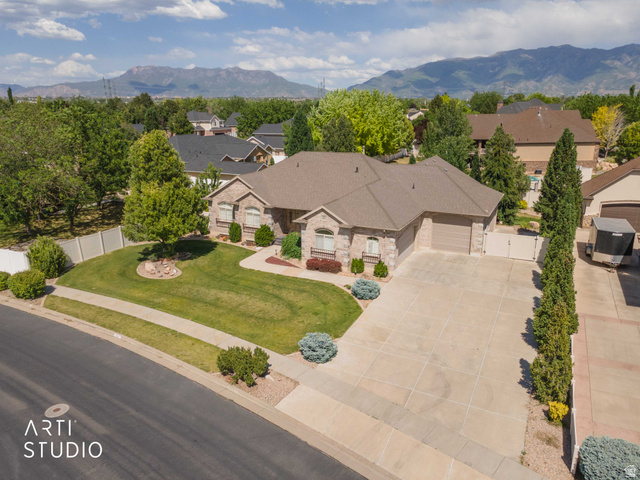 2327 Bluff Ridge Drive Syracuse, UT 84075 - Photo 57 of 66 Expansive property featuring a stone and brick facade, a multi-car driveway, a two-car garage, mature landscaping, and a mountain backdrop