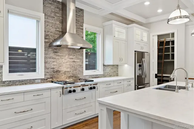 a kitchen with granite countertop a sink stainless steel appliances and cabinets