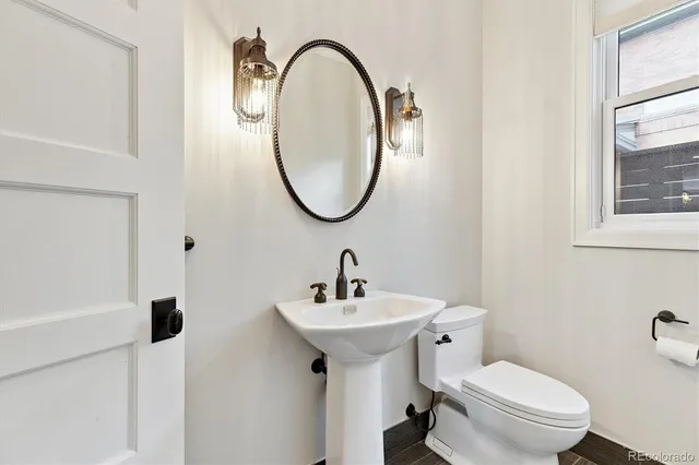 a bathroom with a sink a toilet and a mirror