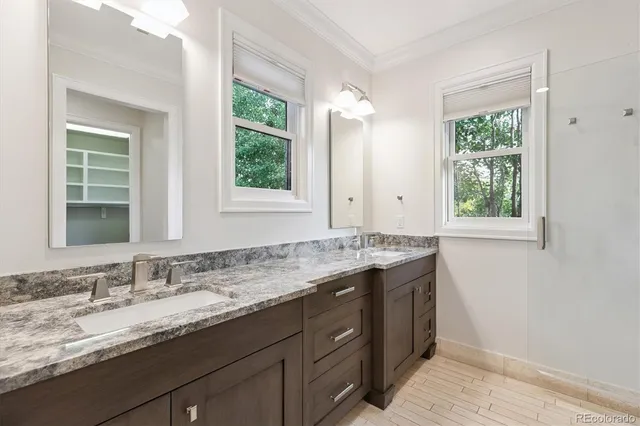 a bathroom with a granite countertop sink and a window