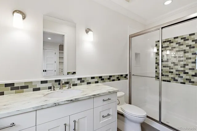 a bathroom with a granite countertop sink toilet and shower