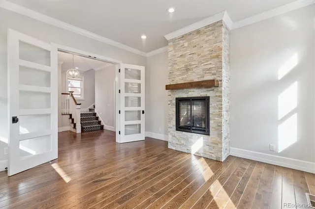an empty room with wooden floor and a fireplace