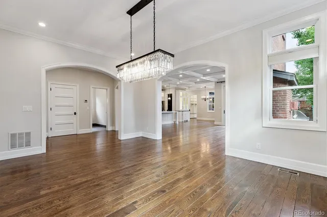 a view of a room with wooden floor staircase and a kitchen space