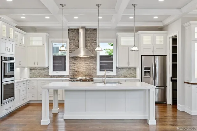 a kitchen with stainless steel appliances kitchen island a refrigerator and a stove top oven