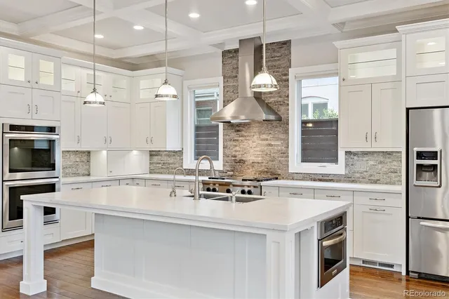a kitchen with stainless steel appliances granite countertop a sink and a refrigerator
