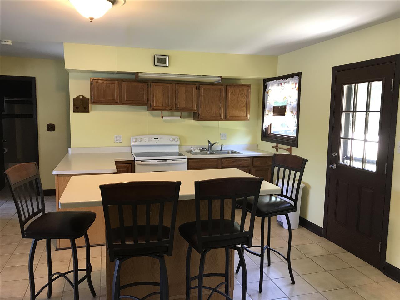 7632 North River Road Byron, IL 61010 - Photo 5 of 15 a kitchen with a dining table chairs and a refrigerator