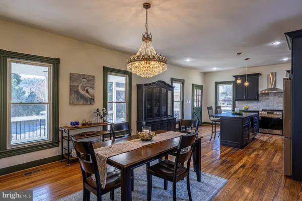 a dining room with furniture a chandelier and wooden floor