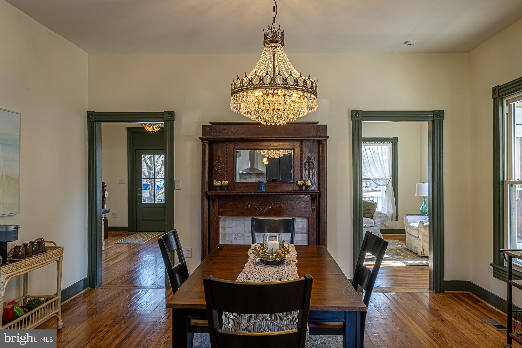 296 Beach Road White Stone, VA 22578 - Photo 14 of 51 a dining room with wooden floor a chandelier a wooden table and chairs