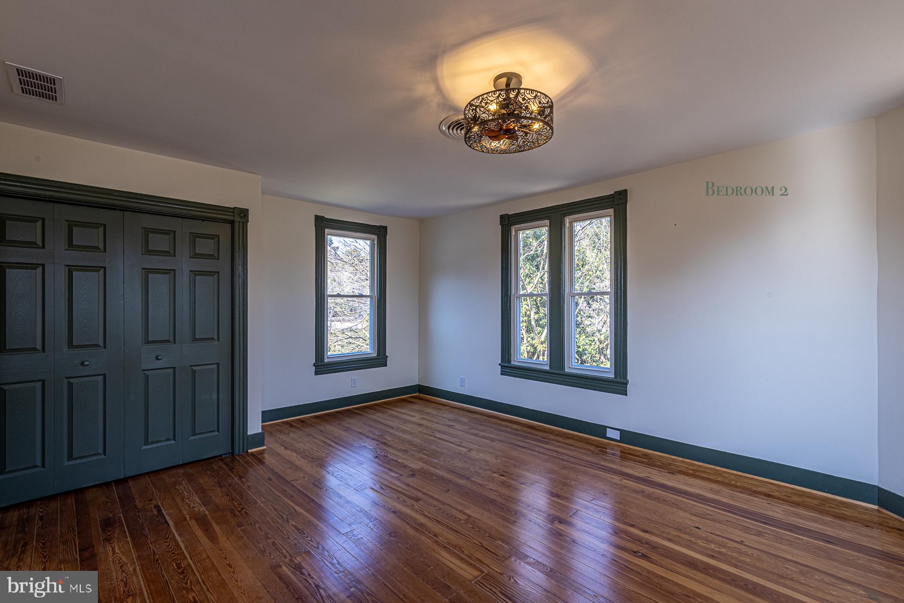 296 Beach Road White Stone, VA 22578 - Photo 33 of 51 an empty room with wooden floor chandelier and windows