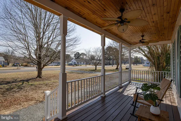 a view of a porch with wooden floor chairs and wooden fence