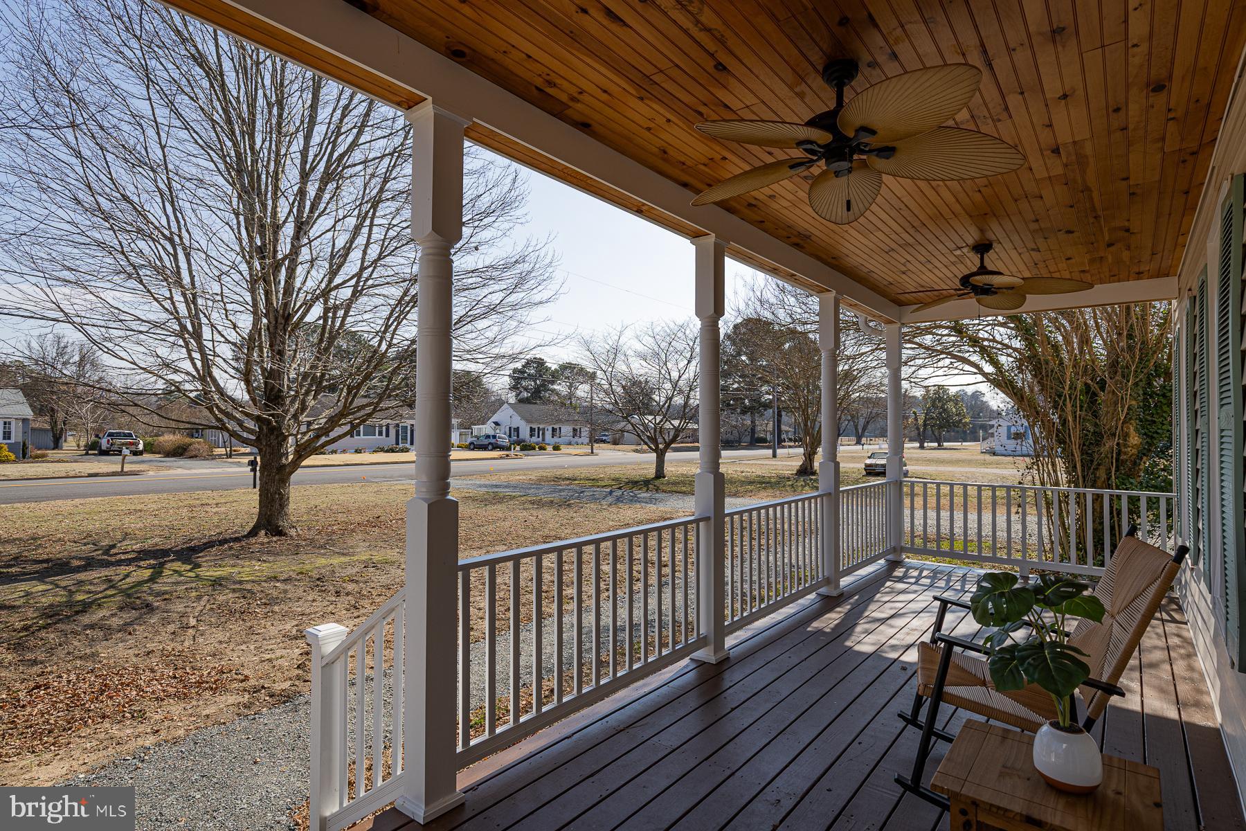 296 Beach Road White Stone, VA 22578 - Photo 4 of 51 a view of a porch with wooden floor chairs and wooden fence
