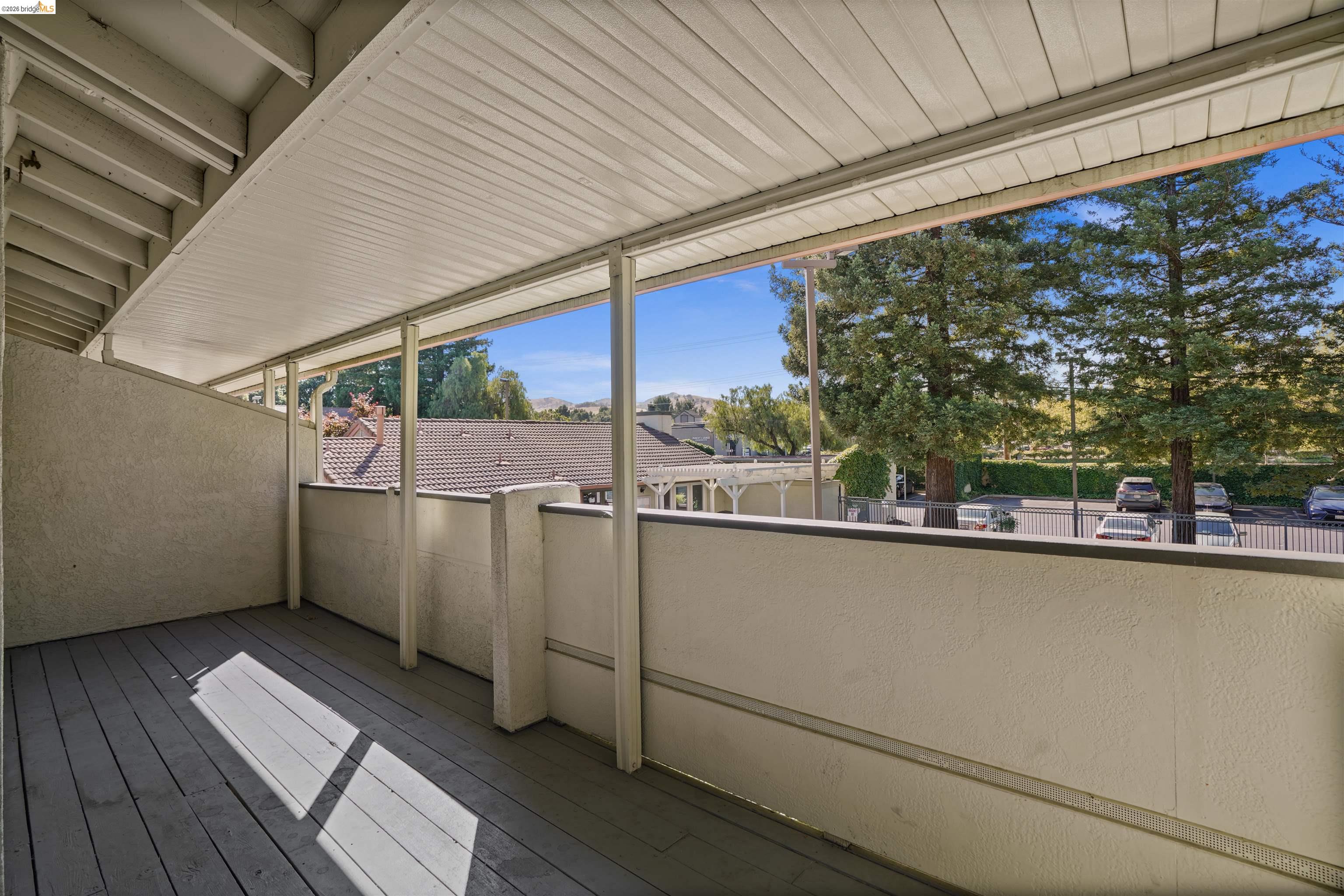 1505 Kirker Pass Road, Unit 214 Concord, CA 94521 - Photo 25 of 55 Covered balcony featuring wood-finish flooring, stucco walls, and a slatted ceiling