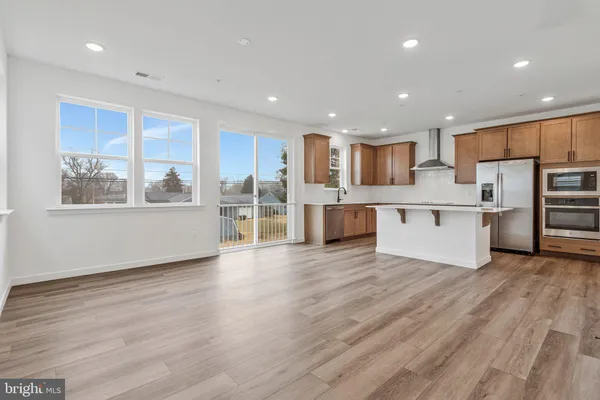 a view of kitchen with wooden floor and electronic appliances