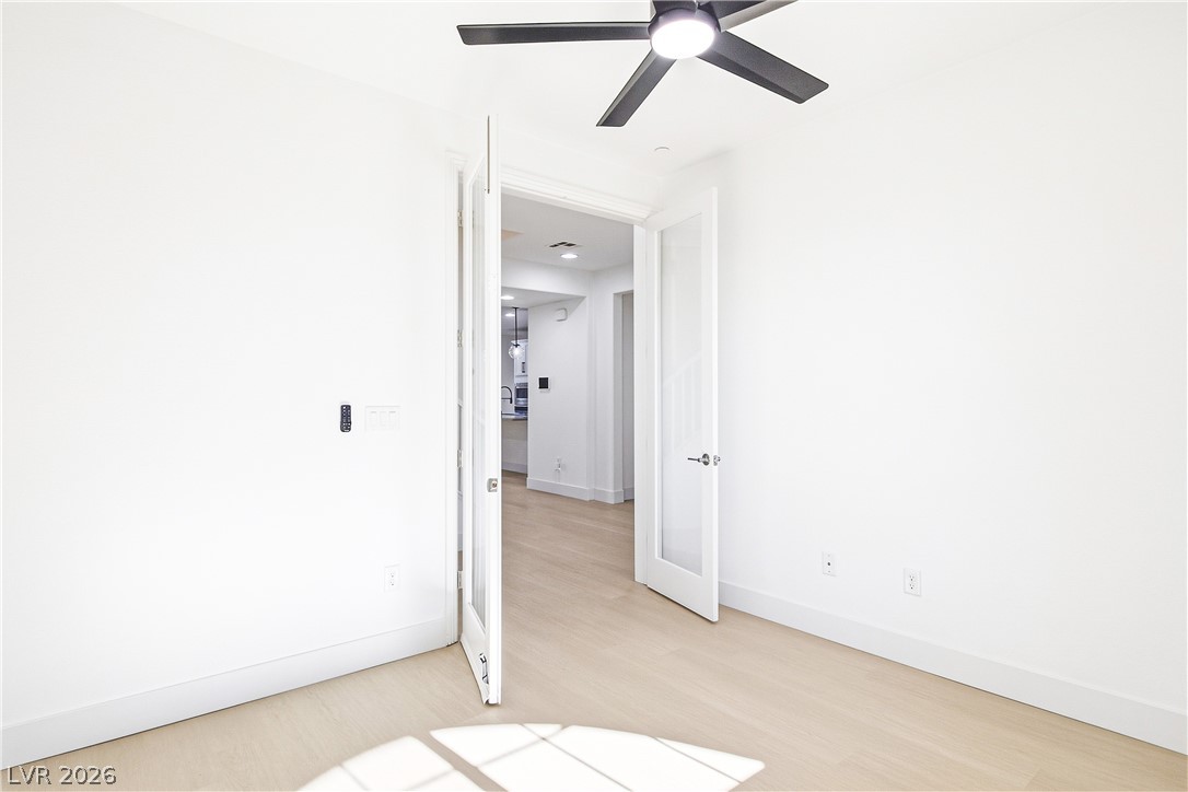 2182 Trivero Street Henderson, NV 89044 - Photo 9 of 50 Double doors open to reveal light-filled interiors showcasing smooth wood flooring and clean lines.