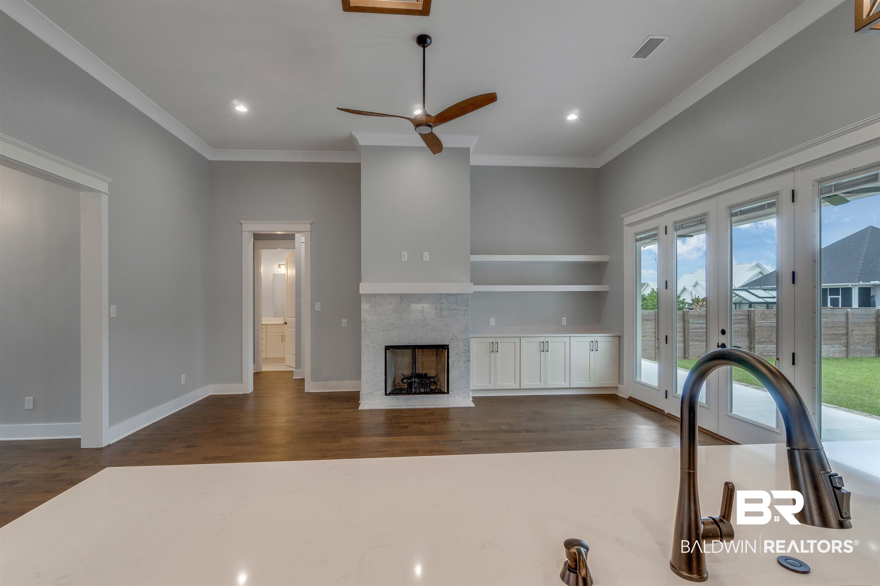 10985 Atrium Avenue Fairhope, AL 36532 - Photo 5 of 58 Unfurnished living room featuring crown molding, a tile fireplace, a ceiling fan, recessed lighting, and dark wood finished floors