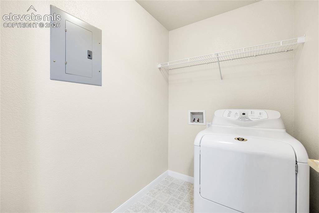 3864 Riviera Grove, Unit 102 Colorado Springs, CO 80922 - Photo 16 of 24 Utility area featuring a built-in wire shelving unit and light-colored patterned flooring