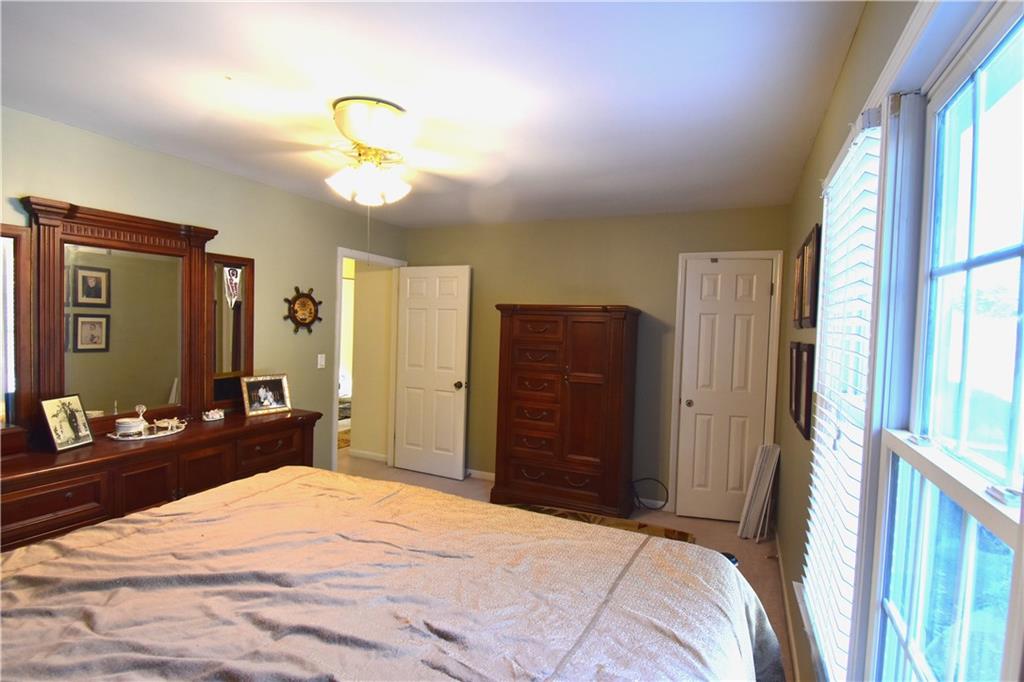 6500 Gaines Ferry Road, Unit I4 Flowery Branch, GA 30542 - Photo 20 of 30 a bedroom with a bed and a chandelier