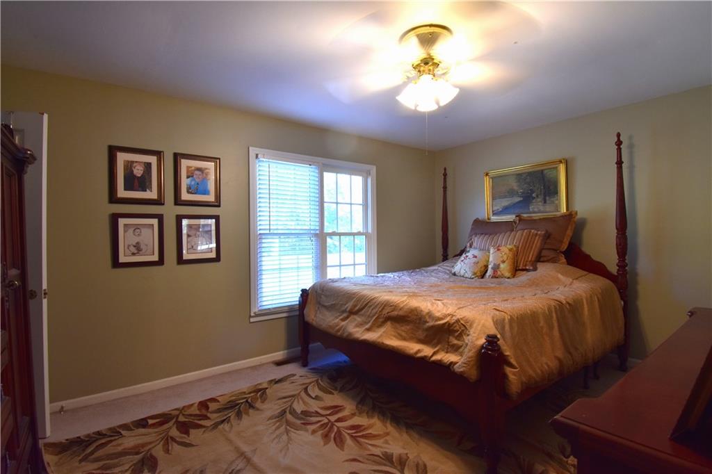 6500 Gaines Ferry Road, Unit I4 Flowery Branch, GA 30542 - Photo 21 of 30 a bedroom with a bed and a chandelier