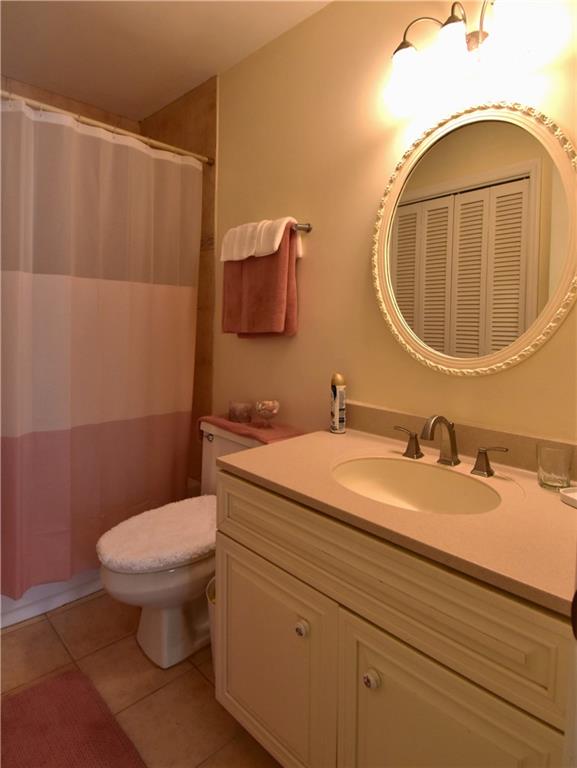 6500 Gaines Ferry Road, Unit I4 Flowery Branch, GA 30542 - Photo 26 of 30 a bathroom with a toilet a sink and mirror