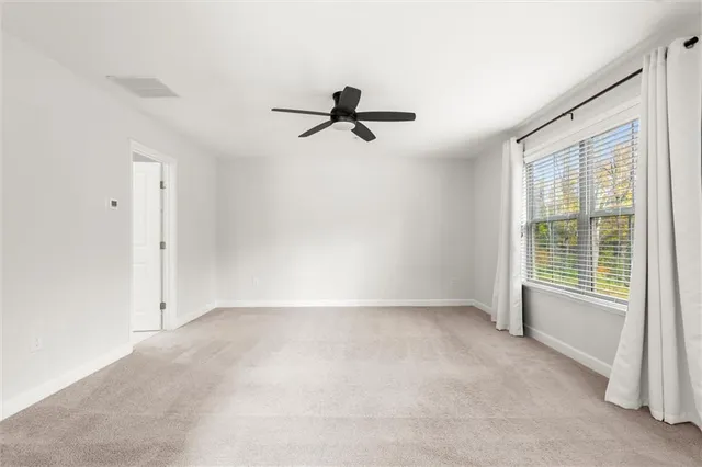 a view of a livingroom with a ceiling fan and window