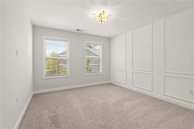 a view of an empty room and chandelier fan