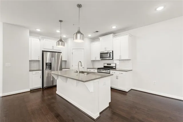 a kitchen with stainless steel appliances kitchen island a sink and a refrigerator