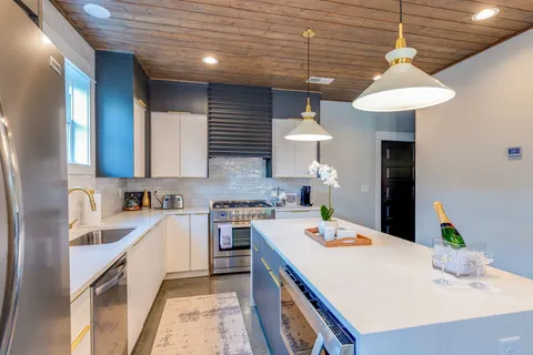 a kitchen with a stove a table and chairs in it