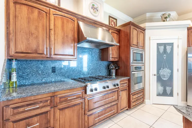 a room with stainless steel appliances lots of wooden furniture a dining table and chairs