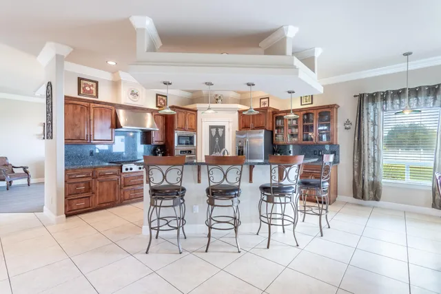 a kitchen with stainless steel appliances kitchen island granite countertop a refrigerator and microwave