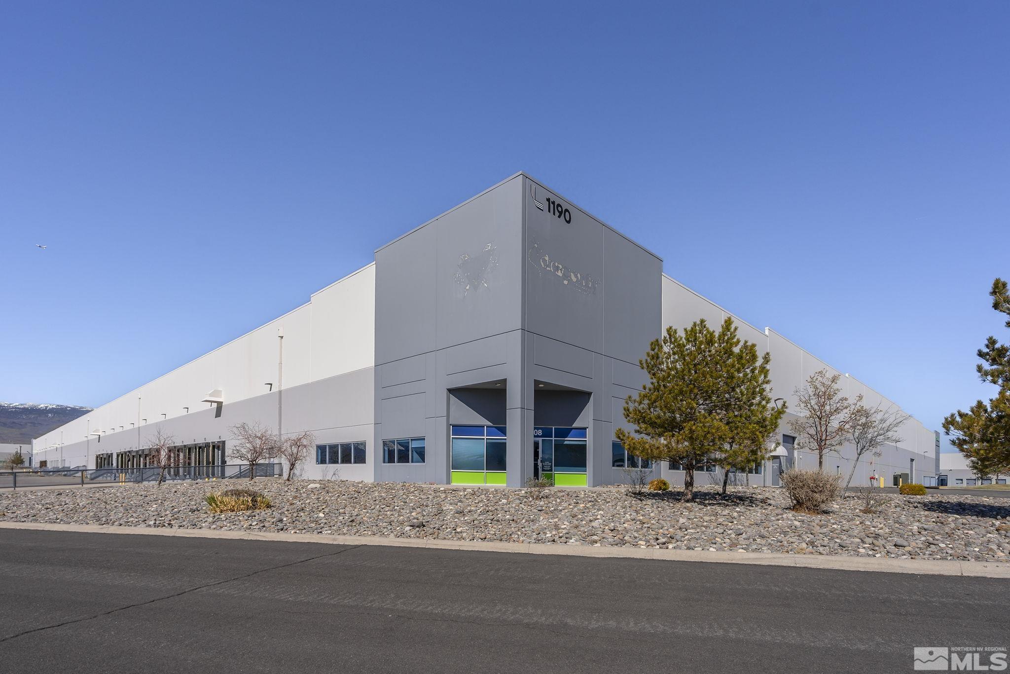 a view of a house with a yard and large tree