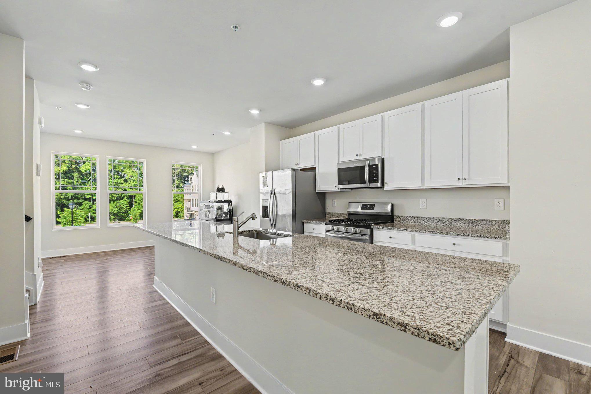 238 Waterstone Road Essex, MD 21221 - Photo 16 of 39 a large kitchen with granite countertop a sink a counter top space appliances and cabinets