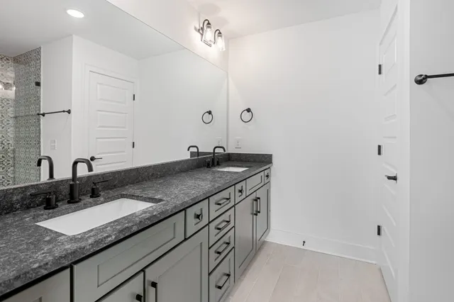 a bathroom with a granite countertop sink and a mirror