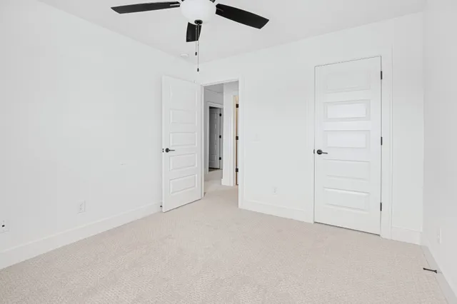 an empty room with chandelier fan