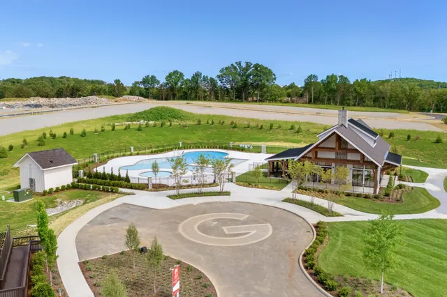 a view of a swimming pool with a yard and plants