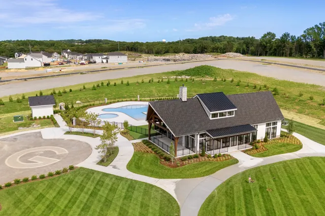 an aerial view of residential houses with outdoor space and ocean view