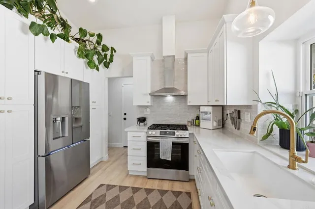 a kitchen with stainless steel appliances a sink a counter space and cabinets