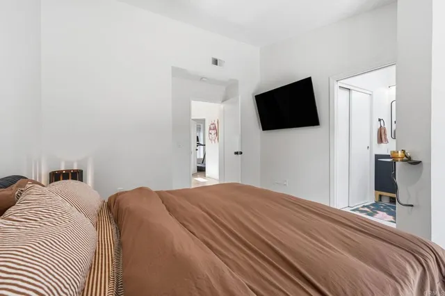 a bedroom with a bed and a flat screen tv