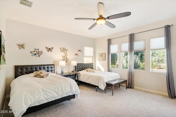 a bedroom with two beds and a large window