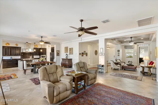 a living room with furniture kitchen view and a chandelier