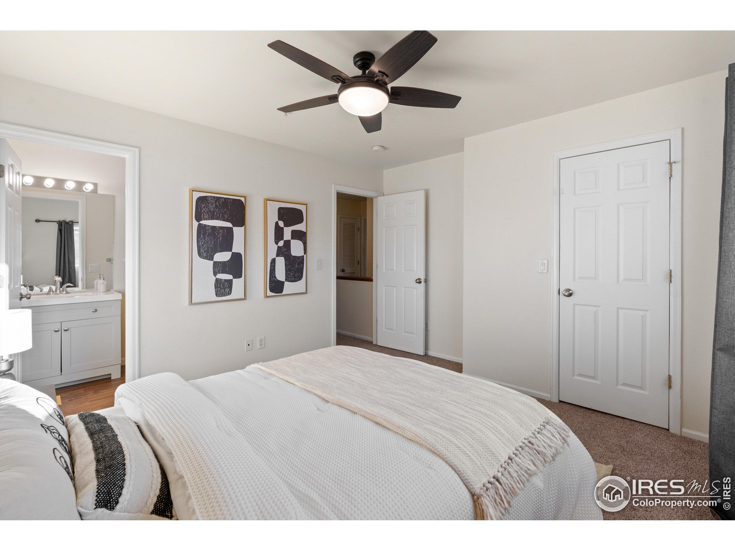 2900 Purcell Street, Unit O4 Brighton, CO 80601 - Photo 20 of 28 a bedroom with a large bed and a chandelier