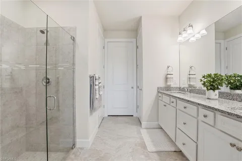 a bathroom with a granite countertop sink a shower and a mirror