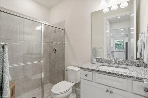 a bathroom with a granite countertop sink toilet and shower