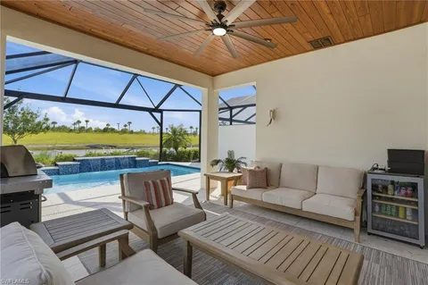 a living room with furniture a ceiling fan and a large window